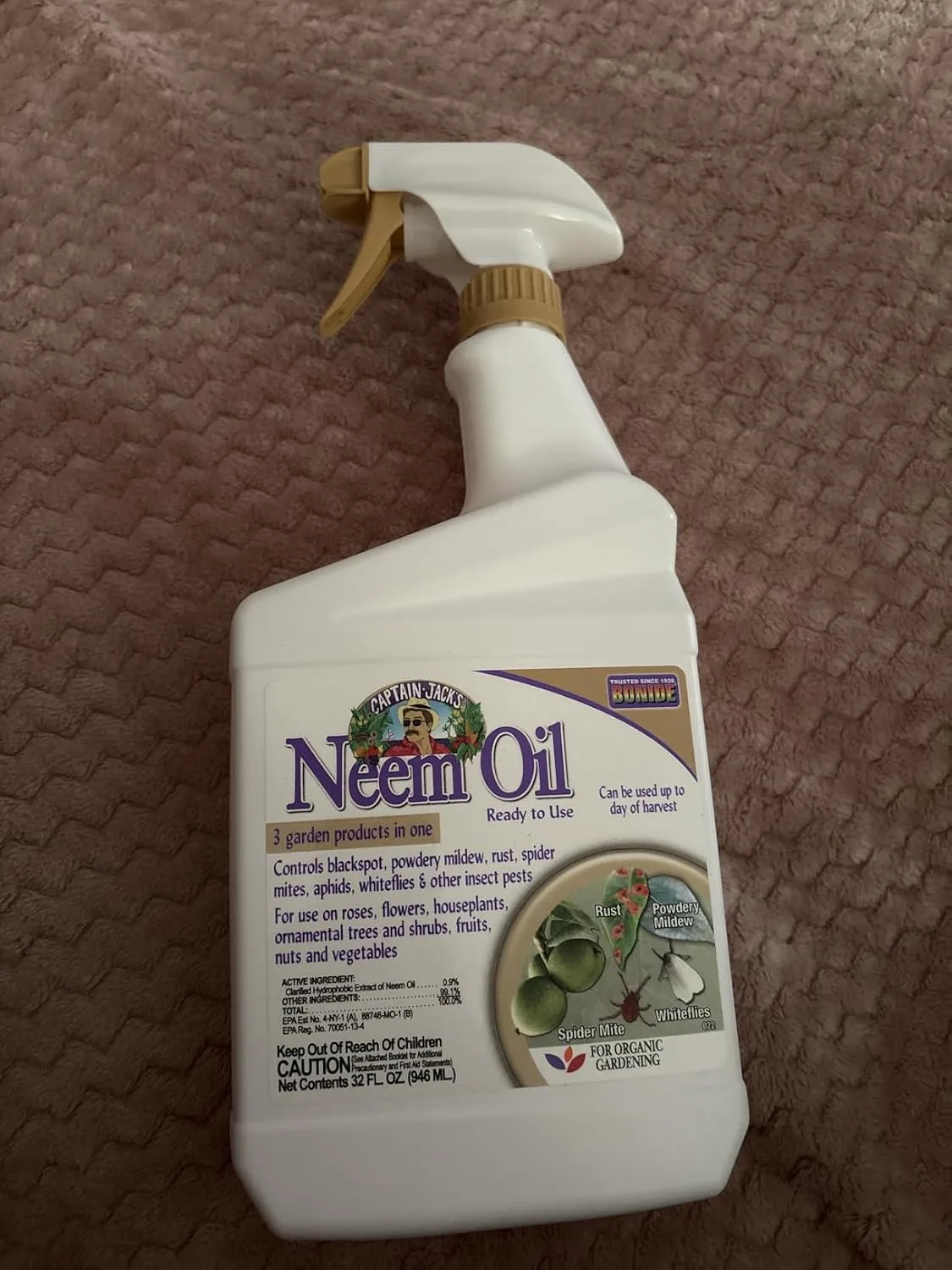 Customer photo of organic pest control spray bottle being applied to camellia plant leaves